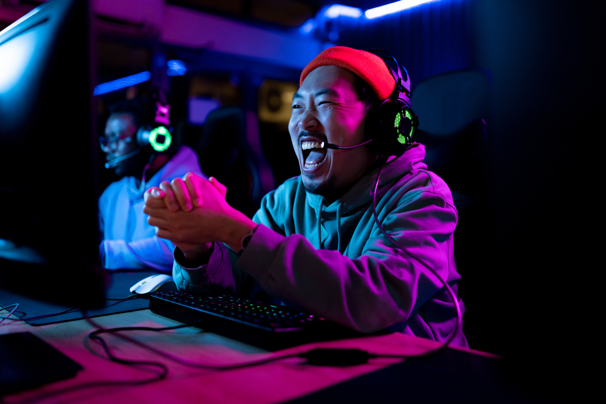 Alt Text Cheerful gamer celebrating his success after winning in video game over PC in gaming club.